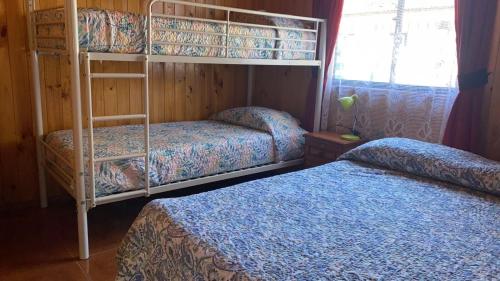 a bedroom with two bunk beds and a window at Cabañas en caburgua in Pucón