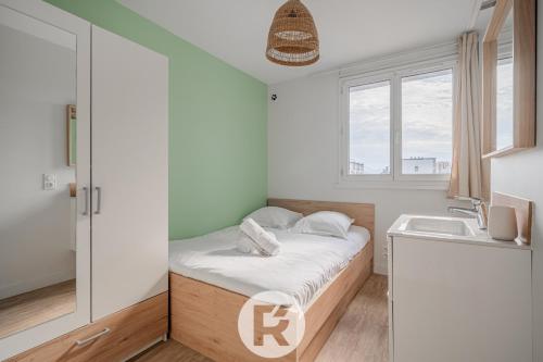 une petite chambre avec un lit et un lavabo dans l'établissement R'Apparts T4 L'atypique, à Grenoble