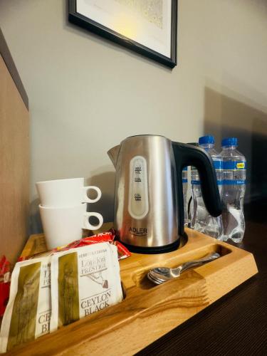 a coffee pot on a wooden counter with a box and spoon at Magiczna Farma Hotel Obiady Mąka i Magia in Zambrów