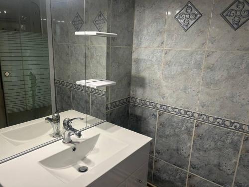 une salle de bain avec un lavabo et un miroir dans l'établissement Apt T2 climatisé à 2 min plage du mole avec balcon et piscine, au Cap d'Agde