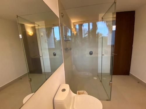 a bathroom with a glass shower and a toilet at Luxury Condo Mareia Ixtapa 101 in Ixtapa