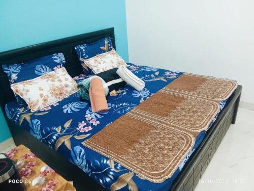 a bed with a blanket and pillows on it at Maa vaishno paying guest house in Ayodhya