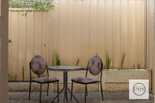 a table and two chairs in front of a fence at Oceanfront Oasis in Bunbury