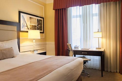 a hotel room with a bed and a desk and a window at The Pickwick Hotel San Francisco in San Francisco