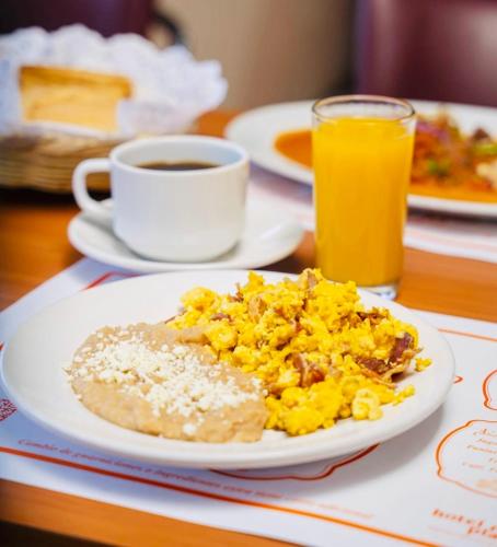 a plate of breakfast food and a cup of coffee at Hotel Real Plaza in San Luis Potosí