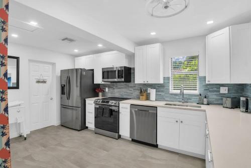 a kitchen with white cabinets and stainless steel appliances at Surfs Up - 4 Bdrm House W Pool in Pompano Beach