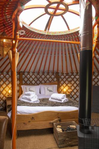 a bed in a yurt with a large window at Lapwing in Bainbridge