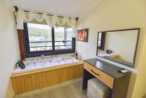 a bathroom with a large tub and a large window at Mykonut Boutique Suites in Fethiye