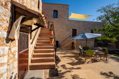 a stone building with a staircase and an umbrella at Pandera areopoli in Areopolis