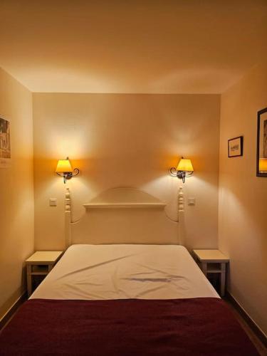 - une chambre avec un lit et deux lumières sur le mur dans l'établissement T2 Ciboure 4 pers avec piscine idéal vacances, à Ciboure