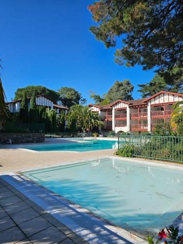 une grande piscine devant un immeuble dans l'établissement T2 Ciboure 4 pers avec piscine idéal vacances, à Ciboure