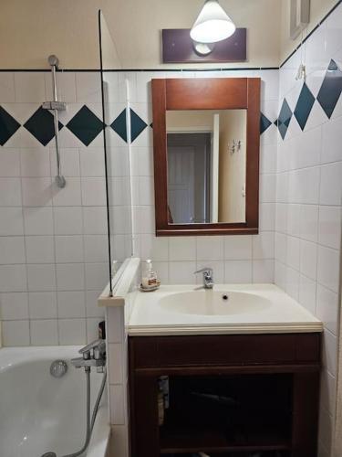 une salle de bain avec un lavabo, une baignoire et un miroir dans l'établissement T2 Ciboure 4 pers avec piscine idéal vacances, à Ciboure