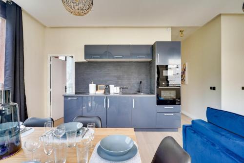 une cuisine avec des armoires bleues et une salle à manger dans l'établissement Bluestay 57 - Charmant appartement à Paris, à Paris