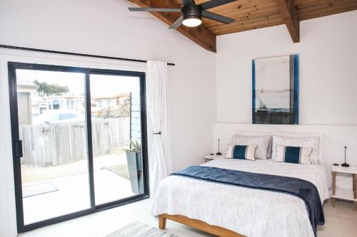Un dormitorio con una cama y una puerta corrediza de vidrio. en 5768 Moonstone Bch Dr., en Cambria