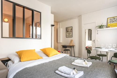 une chambre avec un grand lit avec des serviettes dessus dans l'établissement Charming Apartment - Atelier Lumières - 4 guests, à Paris