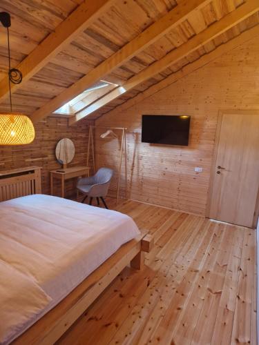 a bedroom with a bed and a tv on a wall at Cabana 278 in Moieciu de Jos