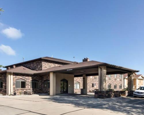 a large brick building with a car parked in front at Quality Suites Near West Acres in Fargo