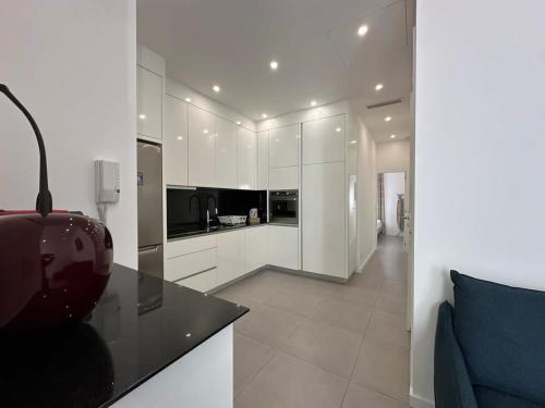 une cuisine avec des placards blancs et un canapé bleu dans l'établissement B080- À l'étroit à l'hôtel Bienvenue chez nous, à Cannes