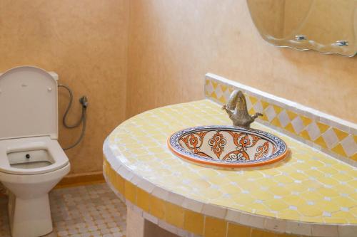 a bathroom with a toilet and a plate on a counter at Panoramic View Villa, 4 Bed, Pool in Mirleft
