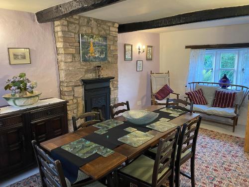 a dining room with a table and a fireplace at The Nook at Ullswater in Penrith