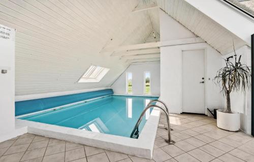 a swimming pool in the middle of a house at Lovely Home In Ringkøbing With Sauna in Ringkøbing
