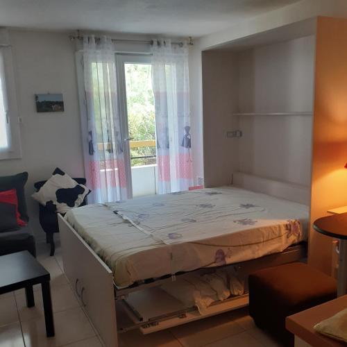 un lit dans une chambre avec une fenêtre dans l'établissement Les cigales de mer, au Grau-du-Roi