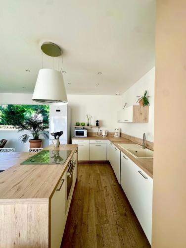 une cuisine avec des armoires blanches et un plancher en bois dans l'établissement VILLA JUWEN, à Oletta