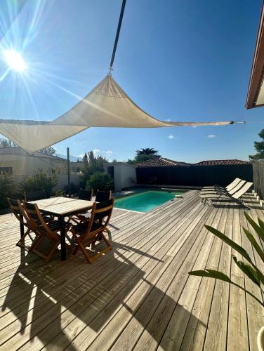 a patio with a table and chairs on a wooden deck at VILLA JUWEN in Oletta