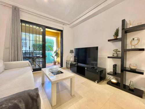 a living room with a couch and a tv and a table at Solmar Javea in Jávea