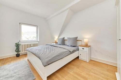 Un dormitorio blanco con una cama y una ventana. en Gestade Fewo 4, en Bernkastel-Kues