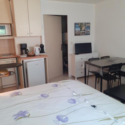 - une chambre avec un lit orné de fleurs violettes dans l'établissement Les cigales de mer, au Grau-du-Roi