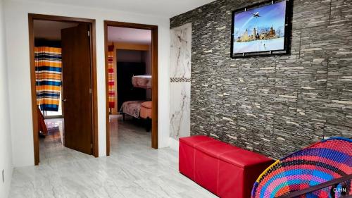 a living room with a tv on a stone wall at Departamento bonito en Santiago Etla in San Sebastián Etla