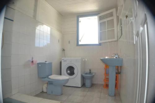 a bathroom with a toilet and a sink and a washing machine at Appartement moderne à Sainte-Luce avec piscine partagée in Sainte-Luce