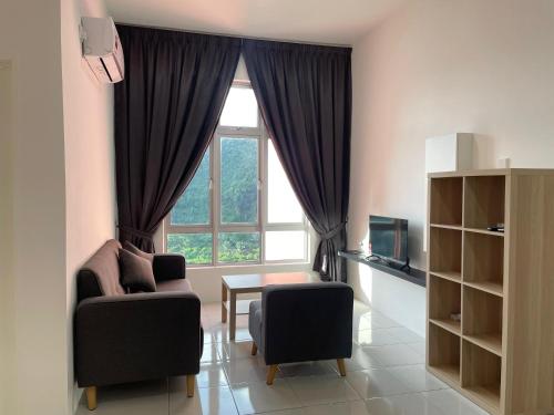 a living room with a window and two chairs and a table at the Anderson Ipoh 2BR by Goswell in Ipoh