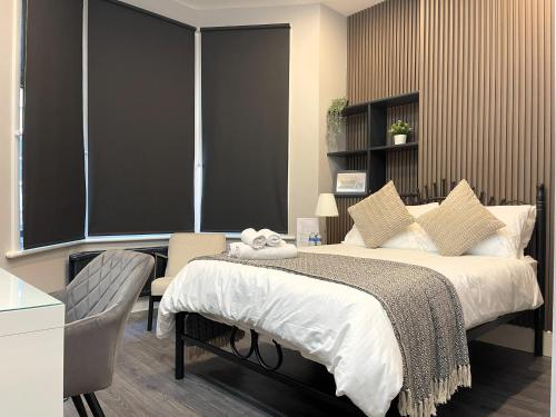 a bedroom with a bed and a desk with a chair at Luxury Guest House in Vibrant London Area in London