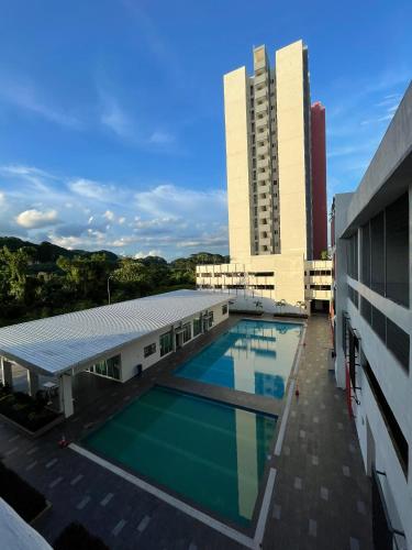 a building with a swimming pool and two tall buildings at the Anderson Ipoh 2BR by Goswell in Ipoh