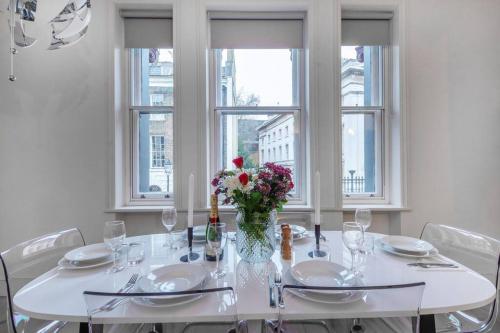 a white dining room table with a vase of flowers at Museum View in London