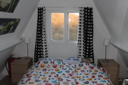 1 dormitorio con cama con edredón y ventana en Bosvilla Ardennen, en Durbuy