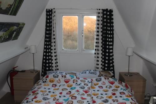 a bedroom with a bed with a comforter and a window at Bosvilla Ardennen in Durbuy