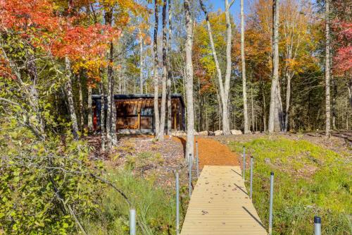 a wooden path through a forest with trees at Private Hot Tub Waterfront Home along Eagle River in Eagle River
