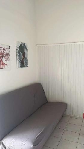 a couch in a room with two pictures on the wall at Appartement confortable à Sainte-Luce avec piscine in Sainte-Luce