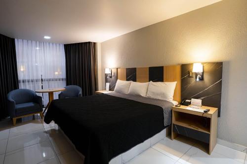 a hotel room with a bed and a table and chairs at Hotel Real Plaza in San Luis Potosí