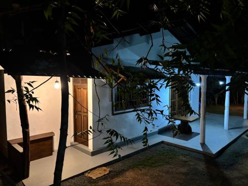 a white house with two windows and a door at Ima House in Hiriketiya