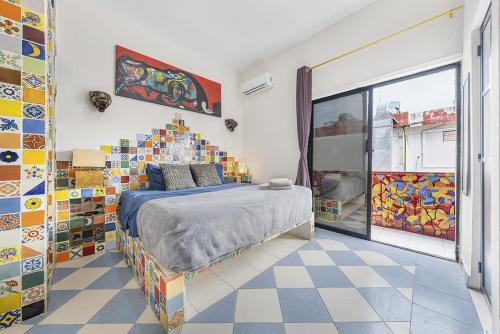 a bedroom with a bed in a room with colorful tiles at Casa Amigos in Isla Mujeres