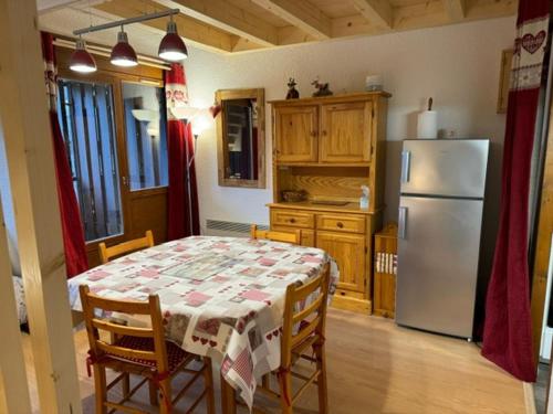 une cuisine avec une table et un réfrigérateur dans l'établissement Appartement rénové avec Multi Pass offert, proche du centre du village ! - FR-1-692-13, à Abondance