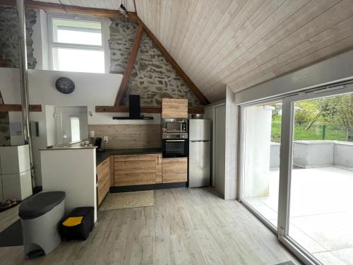 une cuisine avec des placards en bois et une grande fenêtre dans l'établissement Gite chez l'Olivier, à Linthal