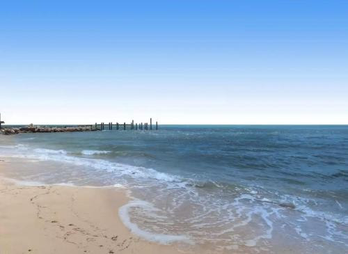 a beach with a pier in the ocean at A Wave From it All in Key Colony Beach
