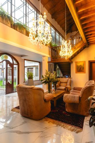 a large living room with leather furniture and a chandelier at Estancia La Elena Hotel Boutique in Tandil