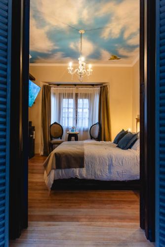 a bedroom with a bed and a chandelier at Estancia La Elena Hotel Boutique in Tandil