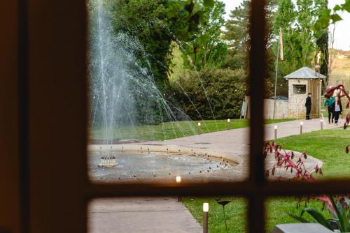 a view of a fountain through a window at Estancia La Elena Hotel Boutique in Tandil
